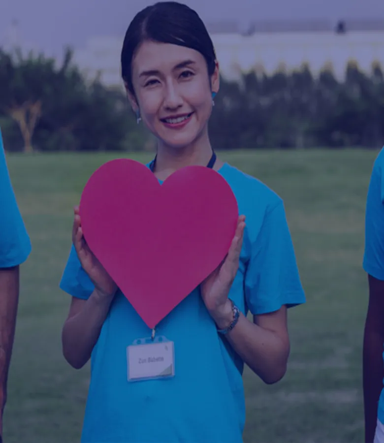 girl standing with a red paper heart with her id card
